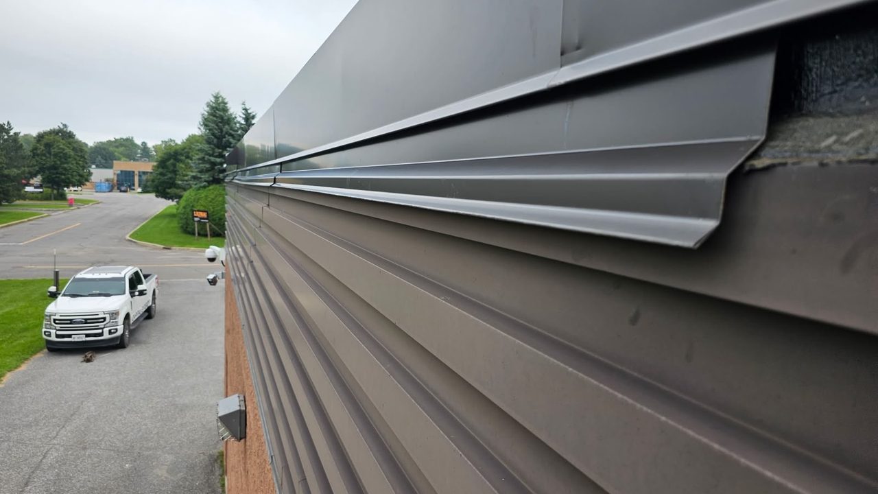 Close-up of a metal coping and flashing detail on a commercial roofline.